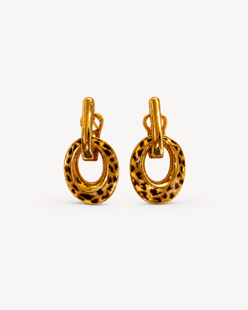 A pair of Theiaura Leopard Loop Hoop Earrings on a clean off-white background
