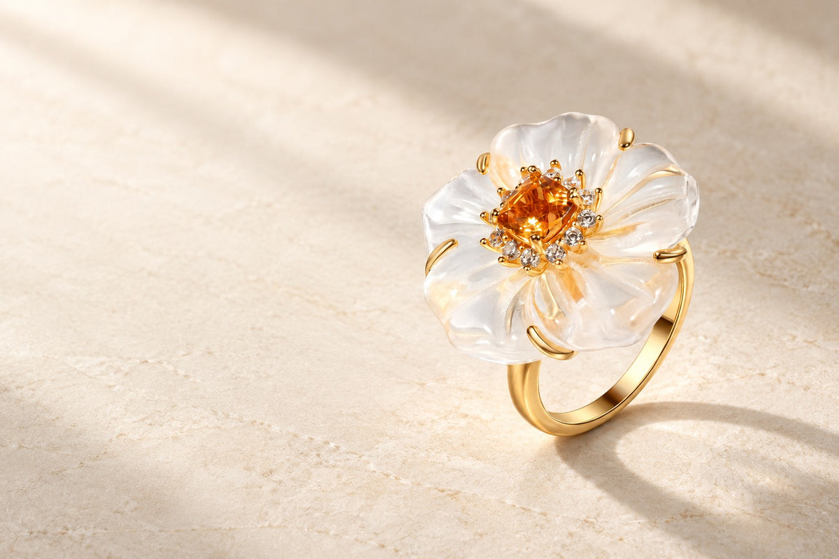 Theiaura Camellia Bloom Ring resting on pale stone in warm light