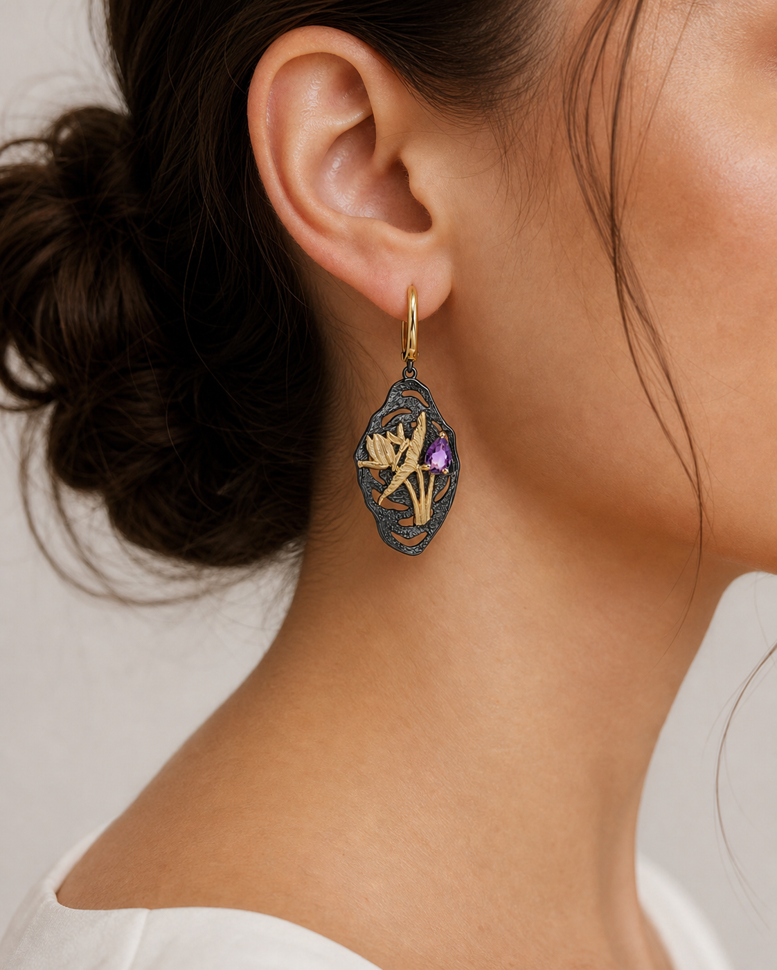 Theiaura Midnight Bloom Drop Earrings in amethyst worn by a woman