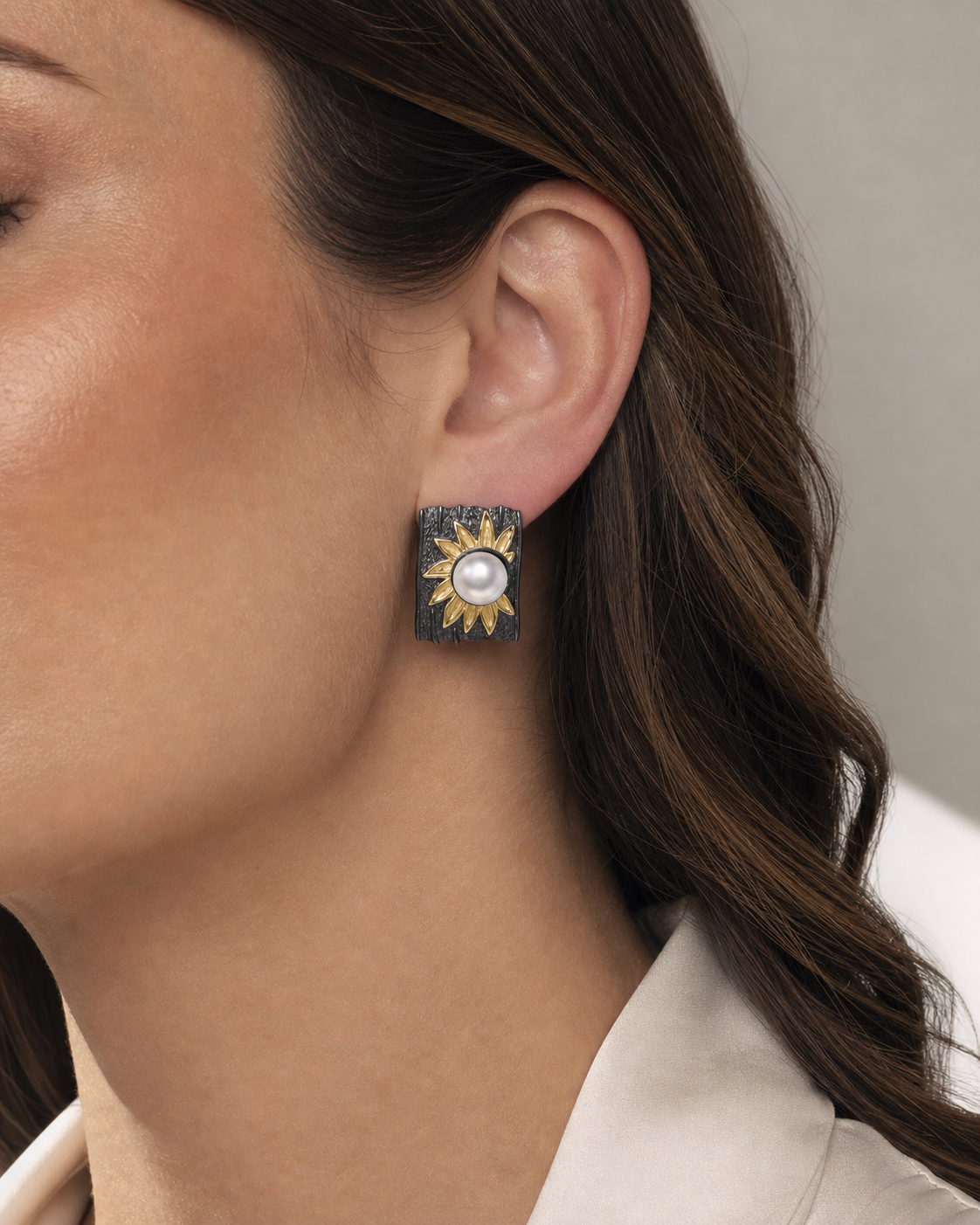 Theiaura Midnight Sunflower Pearl Drop Earrings worn by a woman
